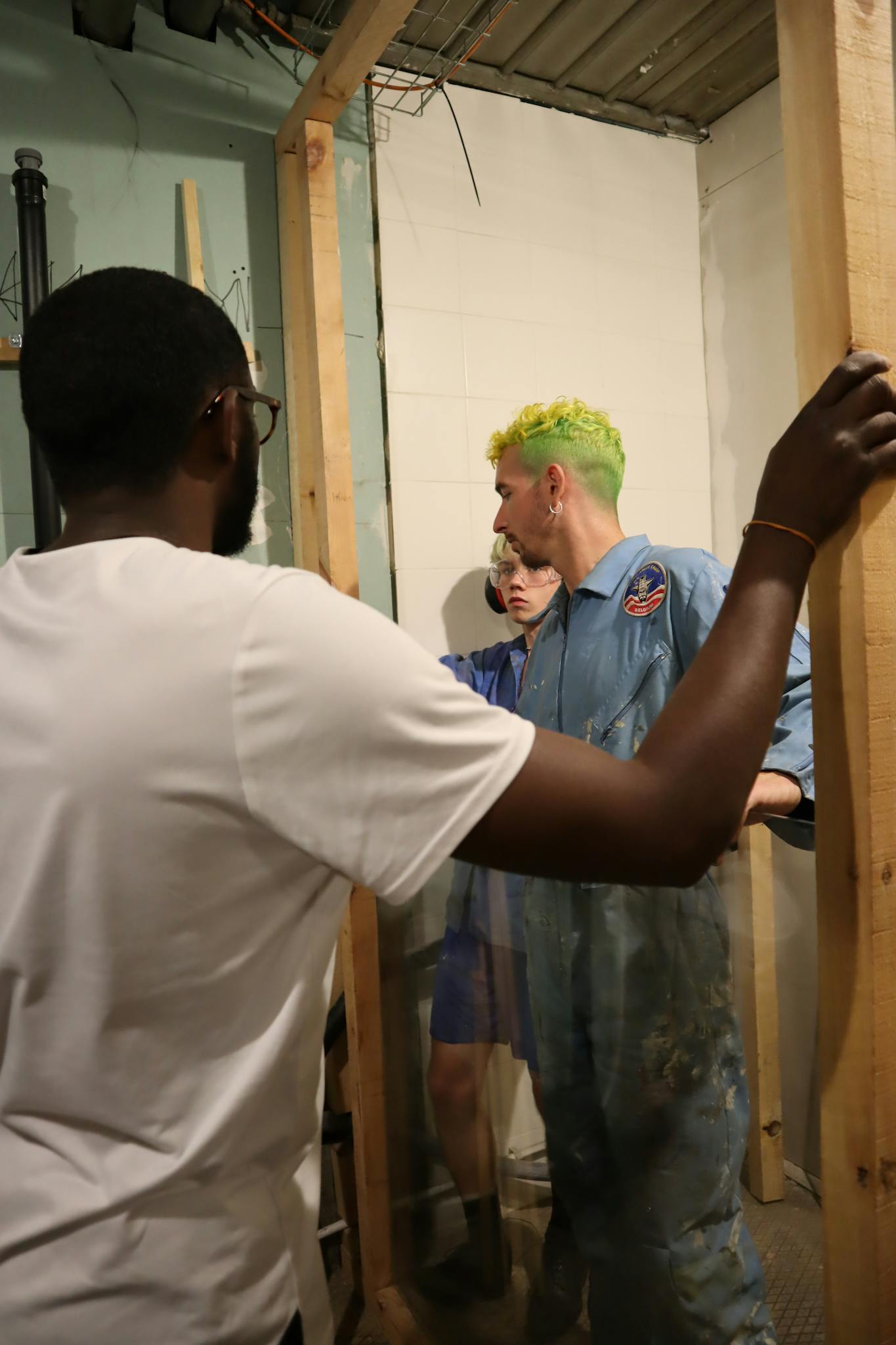 Trzy osoby współpracują przy projekcie budowlanym wewnątrz budynku - stan surowy na Kaszubach.